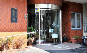 赤レンガ調の建物外壁に設置された円形のガラス製玄関入口